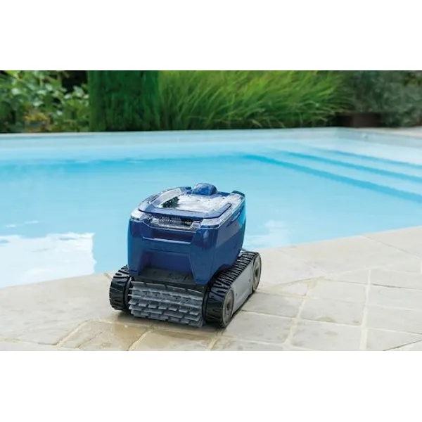 Zodiac RT 3200 poolrobot står upp på plattlagd poolkant, våt efter rengöring, med pool och grönska i bakgrunden.